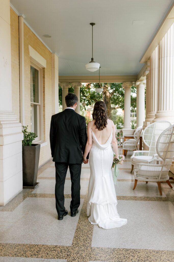 bride and groom walking away on porch at Hotel Ella