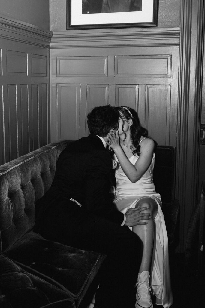 An intimate moment with bride and groom kissing at the bar at Hotel Ella 