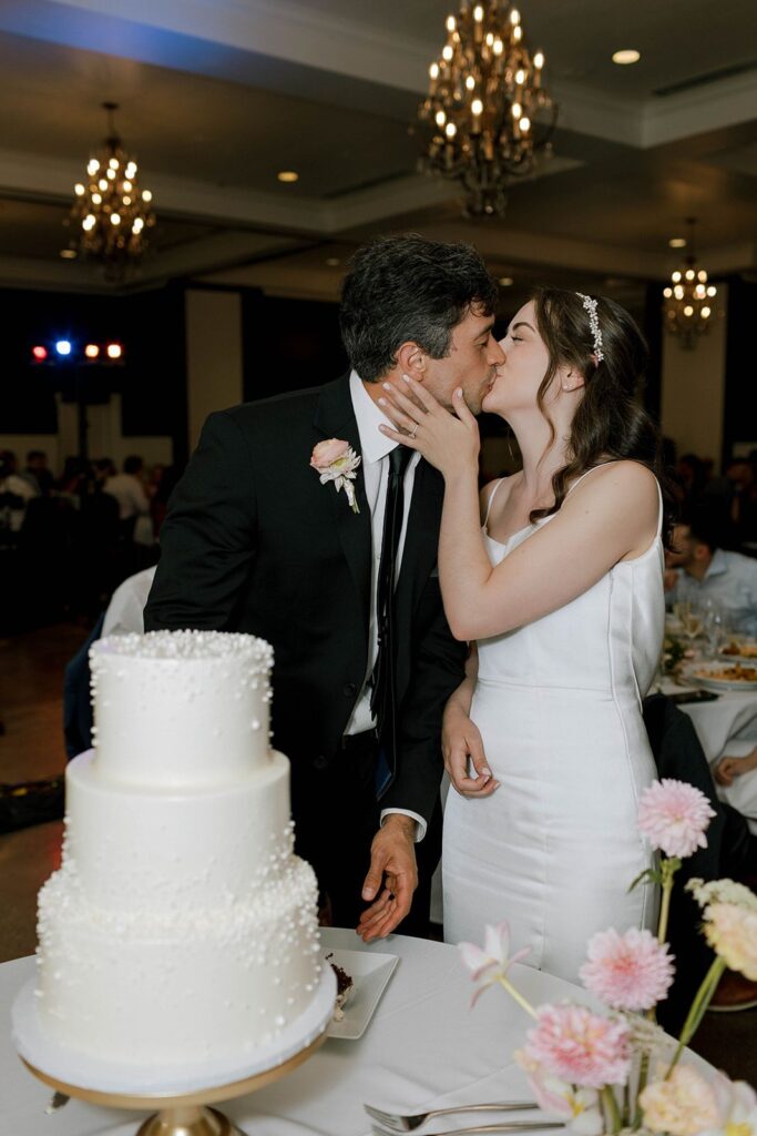 bride and groom kiss after the cake cutting at Hotel Ella wedding 