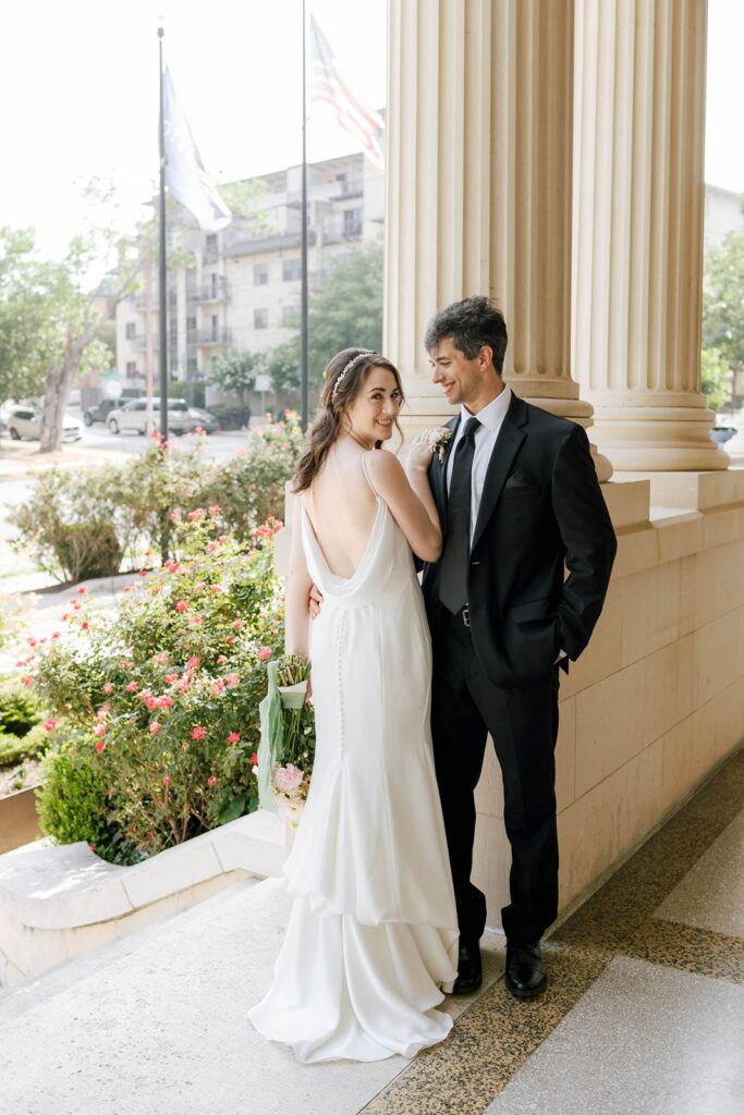 bride and groom posed on the steps of Hotel Ella