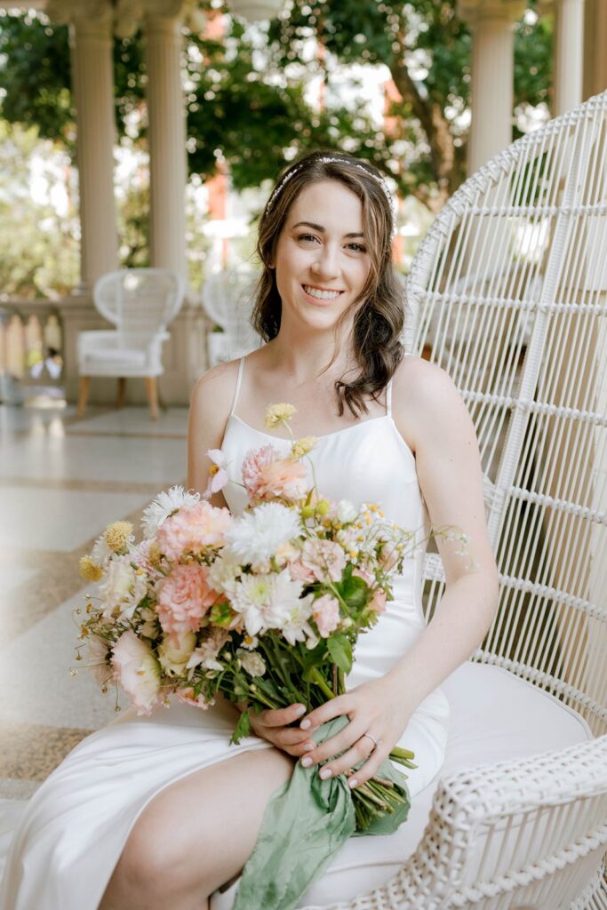 The gorgeous bride seated on the Hotel Ella porch with bridal bouquet