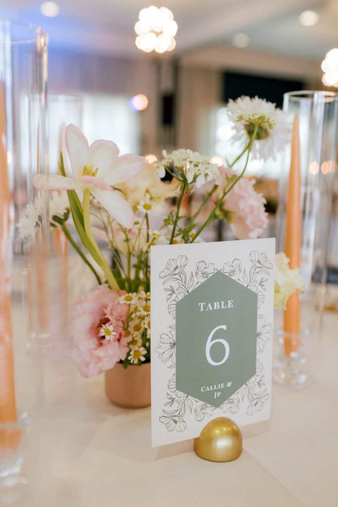 Table number sign and bud vase flower arrangement on tablescape